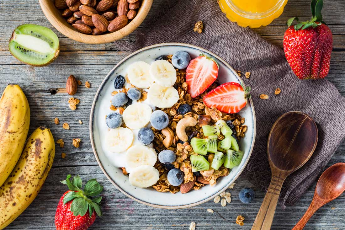 Клубника, банан, черниках, киви, орехи, хлопья в миске Ягоды, фрукты, хлопья, орехи в миске