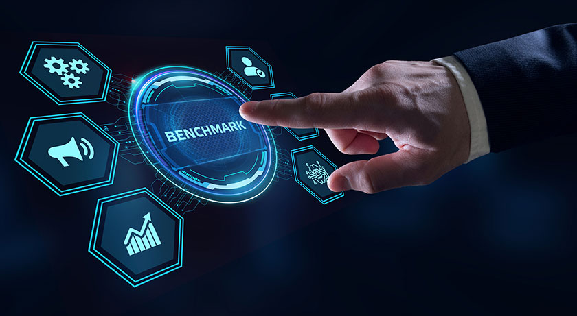 Рука нажимает на кнопку с надписью Benchmark в окружении иконок с бизнес-символикой Рука нажимает на надпись Benchmark