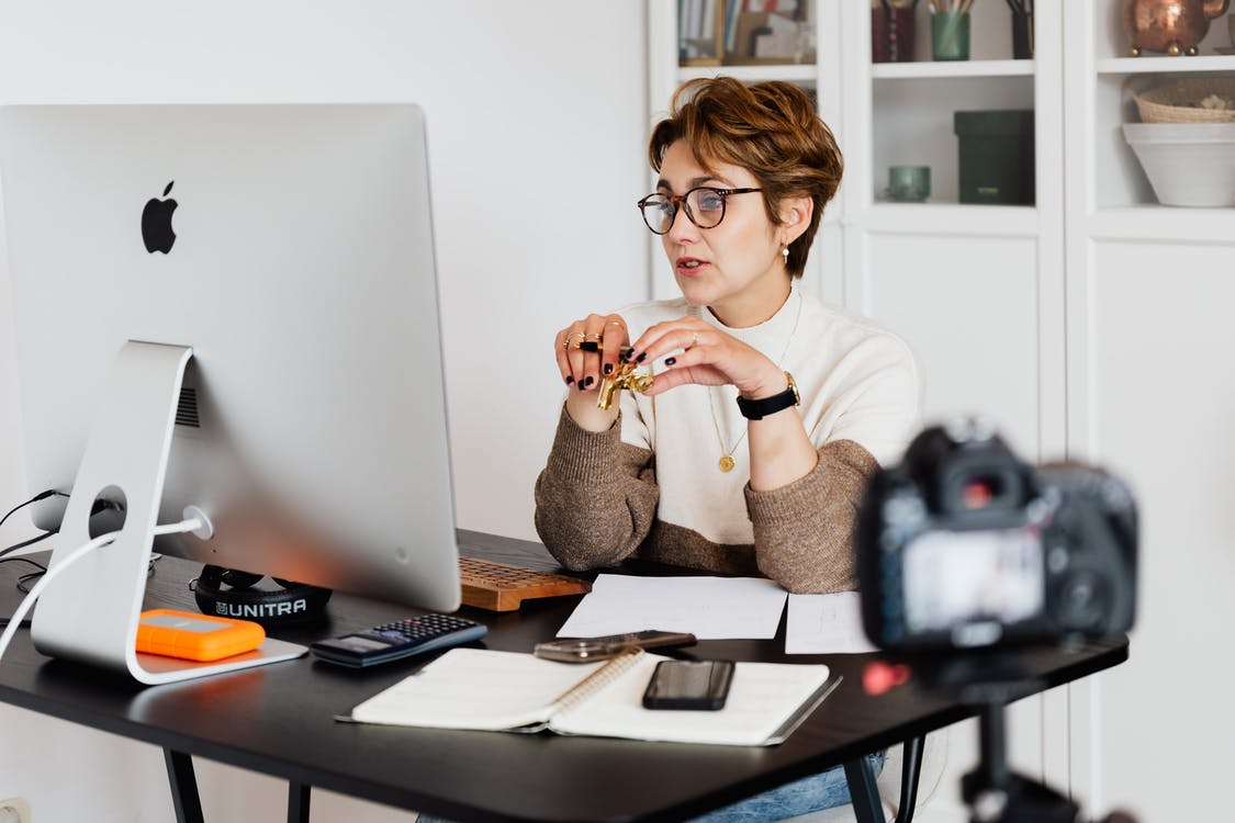 Женщина в очках проводит вебинар, сидя за компьютером